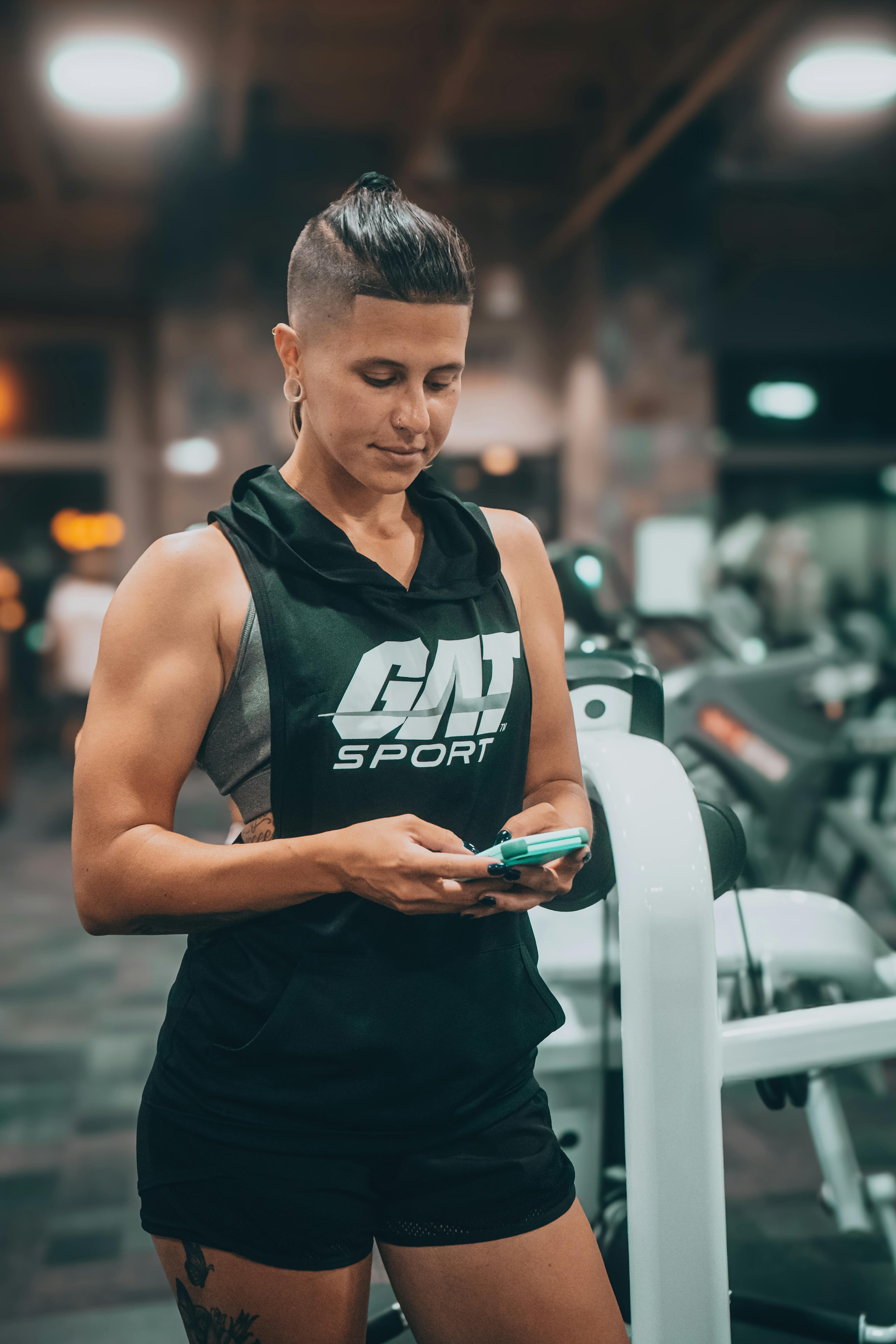 Athlete checking a nutrition app on her phone inside the gym