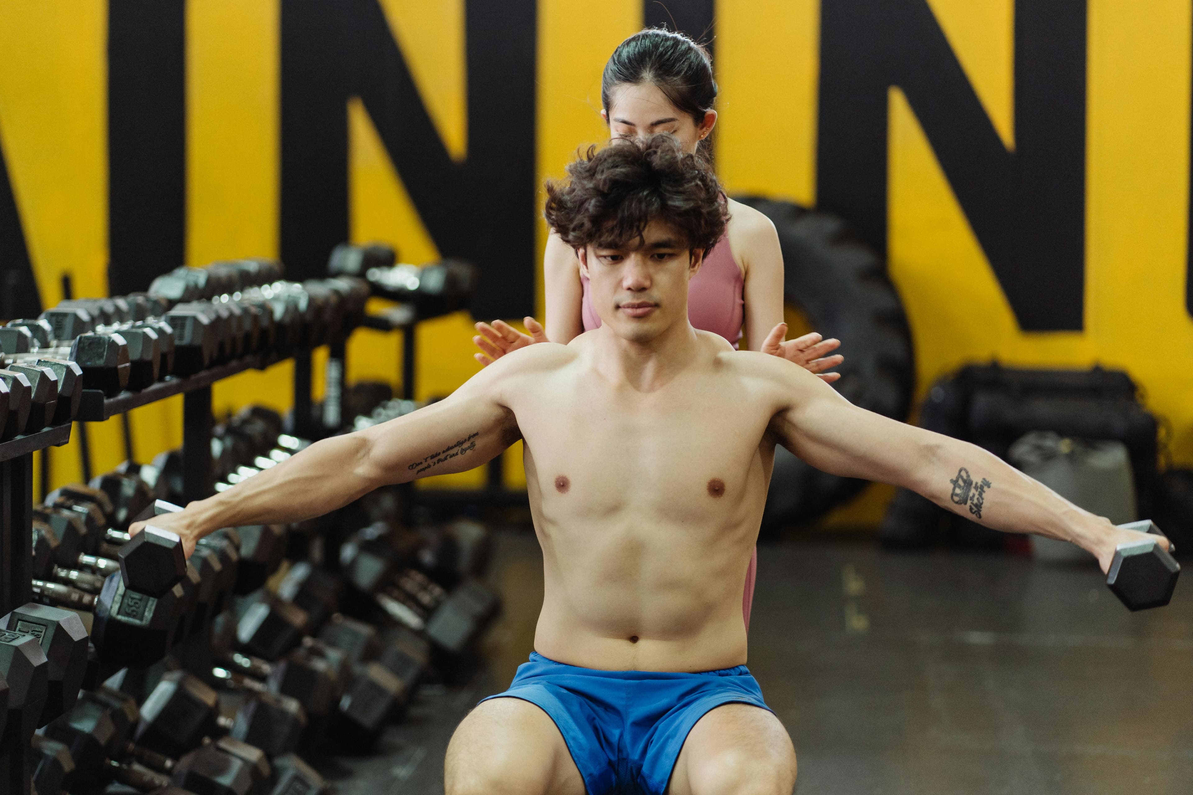 Athlete pushing a hard dumbbell set in the gym