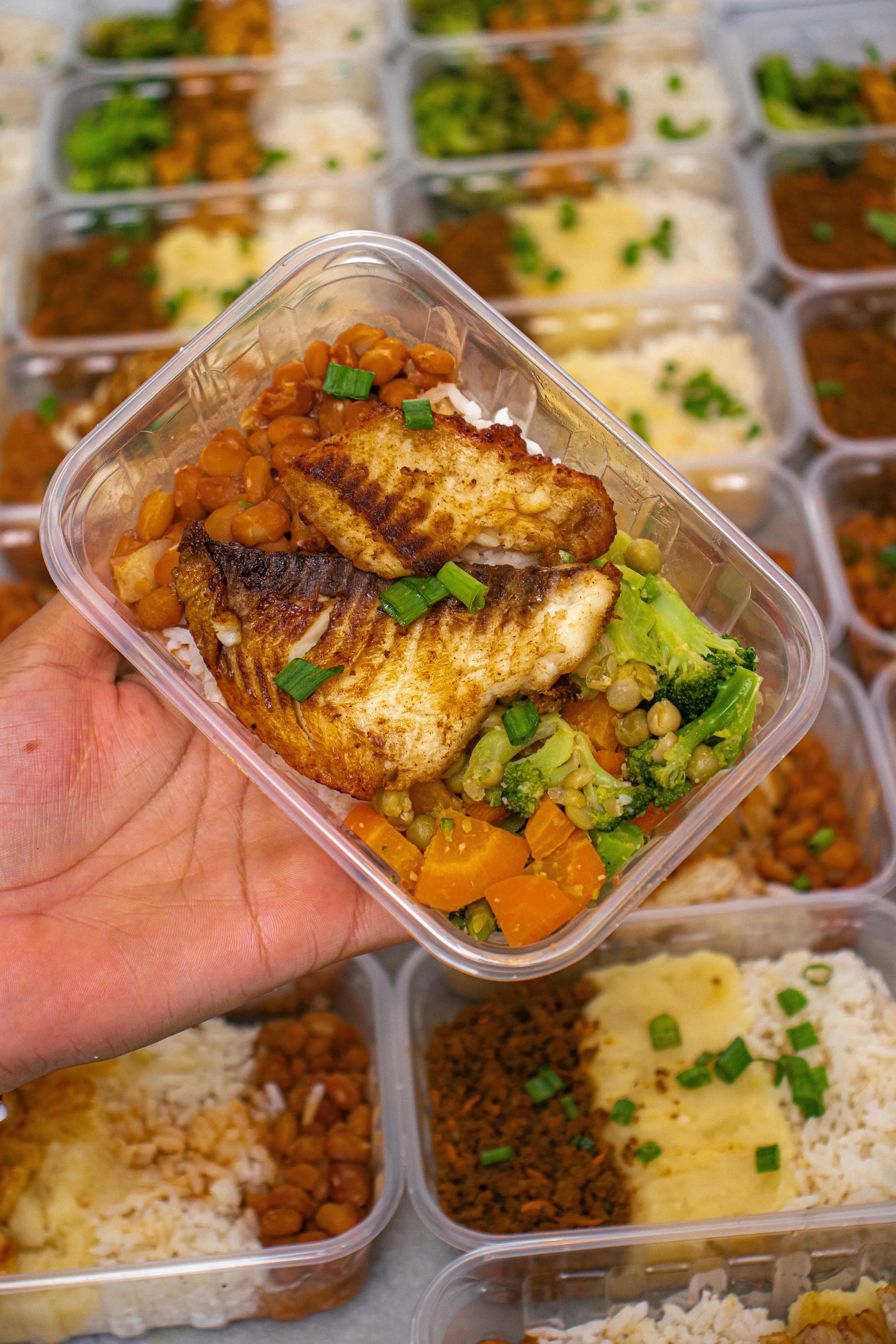 Meal prep container with fish, rice, and vegetables for macro consistency